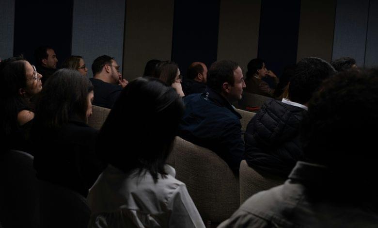 a group of people sitting in a dark room