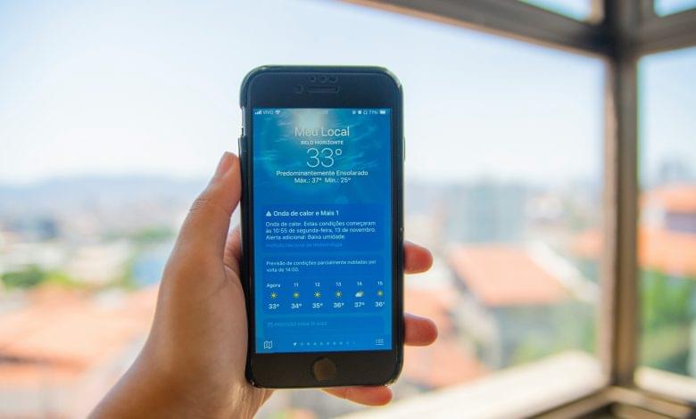 a person holding a cell phone in front of a window
